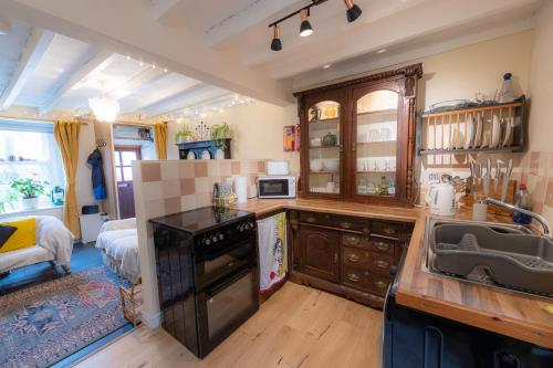 a kitchen with a sink and a counter top at Tri deg un, cottage for 2 adults and 2 children in Machynlleth