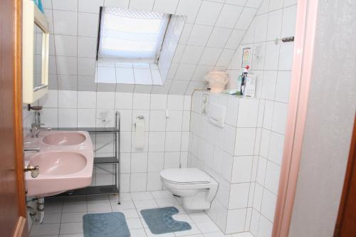 a white bathroom with a sink and a toilet at Ferienwohnung 1 Jöbstl 