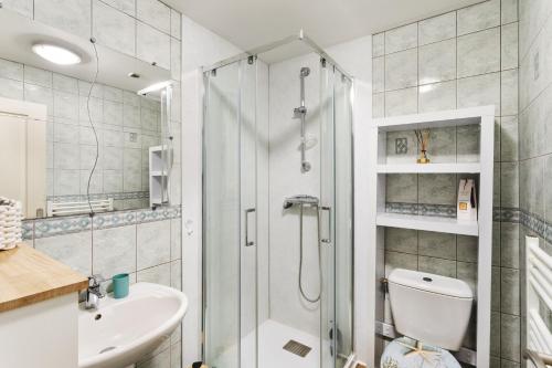 a bathroom with a shower and a toilet and a sink at Les Petits Matelots - Maison proche plage in Saint-Coulomb