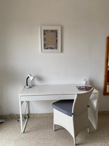 einen weißen Schreibtisch mit einem Stuhl und einem Bild an der Wand in der Unterkunft Home Sweet Home in St Julian's