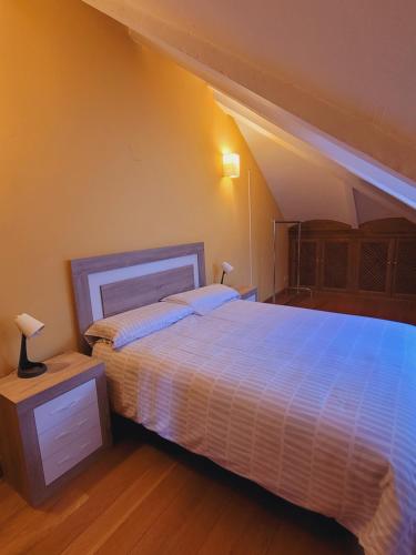ein Schlafzimmer mit einem großen Bett in einem Zimmer mit Dachgeschoss in der Unterkunft El Robledal - Miraflores de la Sierra in Miraflores de la Sierra