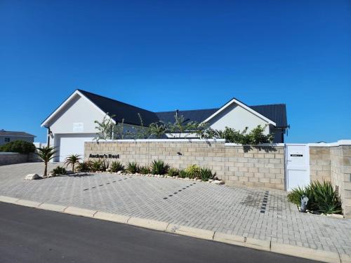 a house with a retaining wall and a brick driveway at Anchor's Rest in Yzerfontein