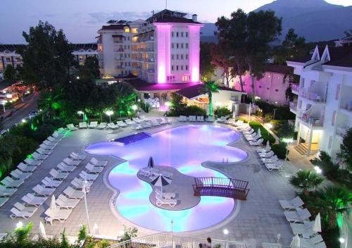 a large swimming pool in a city at night at MIRAMOR HOTEL & Spa - ULTRA ALL INCLUSIVE in Antalya