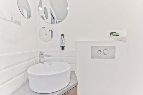 Baño blanco con aseo blanco y lavamanos en BmyGuest - Fado Central Studio, en Lisboa