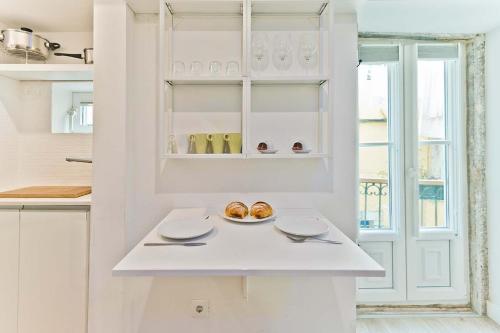una cocina blanca con un plato de donuts en la barra en BmyGuest - Fado Central Studio, en Lisboa