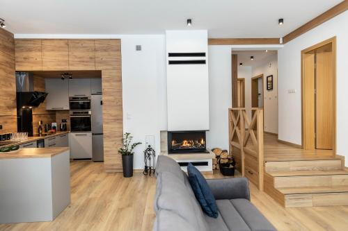 a living room with a couch and a fireplace at udanypobyt Apartamenty Czorsztyn Panorama 2 B in Czorsztyn