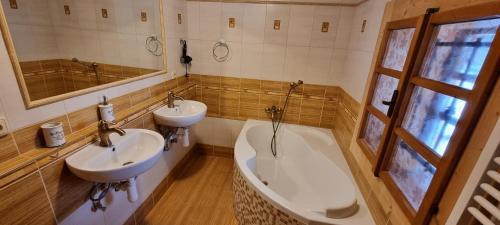 a bathroom with a tub and a sink and a bath tub at Palčovka Huty - apartmán U Ondry a U Andělky in Huty