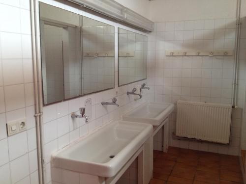 a white bathroom with two sinks and a mirror at Alberg L'Escala Xanascat in L'Escala