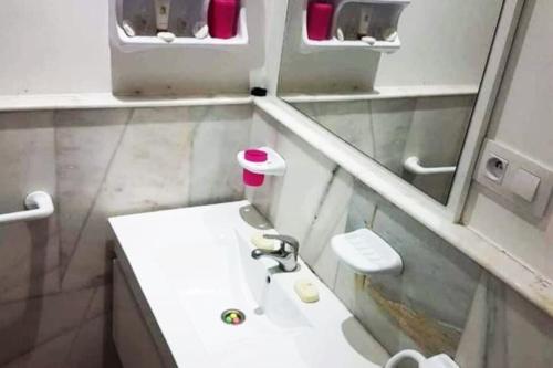 a small bathroom with a sink and a mirror at Appartement d'hôtes familiale Dar ziko wow in El Jadida