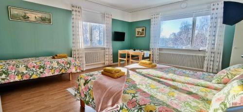 a room with two beds and a table in it at Kronlund Kursgård in Vindeln