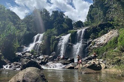 a group of people standing in front of a waterfall at Hospedajes el Jardin cabaña in Concepción