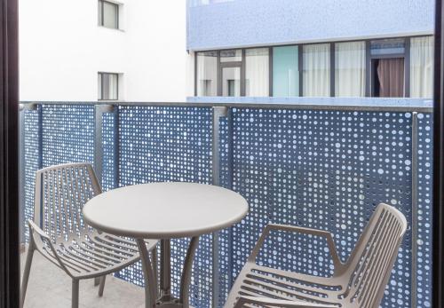 a table and two chairs and a table on a balcony at Hotel Macià Sevilla Kubb in Seville