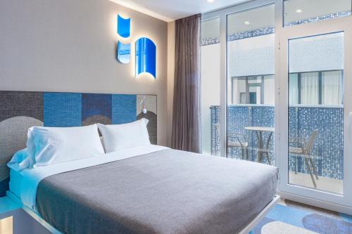 a hotel room with a bed and a balcony at Hotel Macià Sevilla Kubb in Seville