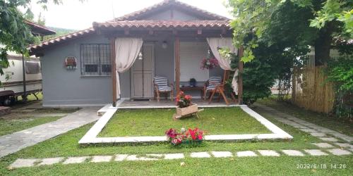 ein kleines Haus mit einem Tisch und Stühlen im Hof in der Unterkunft Sevi Platamon Home in Platamonas