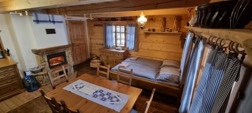 a bedroom with a bed and a table and a fireplace at Palčovka Huty - apartmán U Ondry a U Andělky in Huty