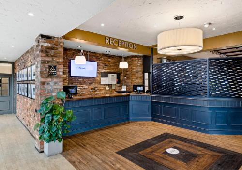 a reception area of a restaurant with a brick wall at Dragonfly Hotel Colchester in Colchester