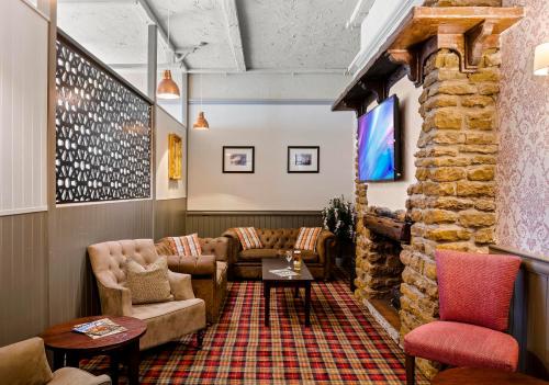 a living room with couches and a stone wall at Dragonfly Hotel Colchester in Colchester