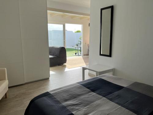 a bedroom with a bed and a couch and a mirror at Loft en zona rural de Lanzarote in Conil