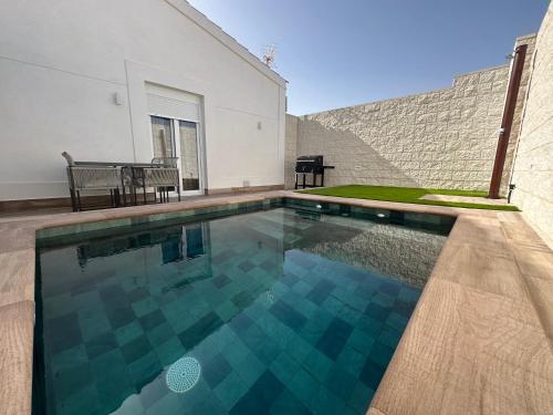 a swimming pool in the backyard of a house at Huellas de la Mancha in Burguillos de Toledo