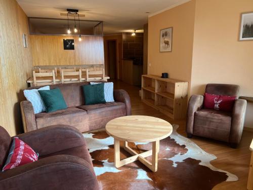 a living room with couches and a table and chairs at Eden Resort Anzère in Anzère