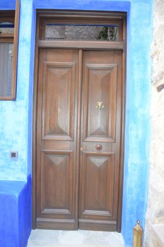 a large wooden door in a blue building at Casa Muse Kastellorizo Whole House in Meyisti