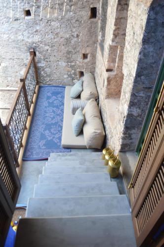 a staircase with pillows and a couch on it at Casa Muse Kastellorizo Whole House in Meyisti