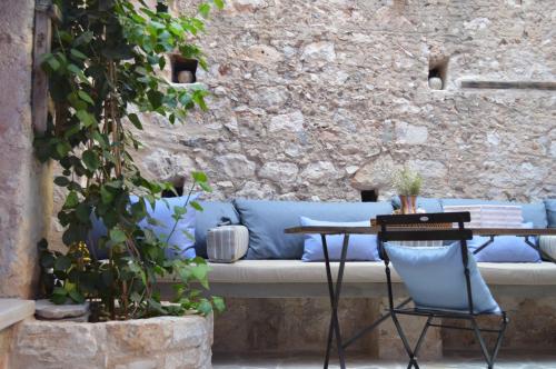 a blue couch sitting next to a stone wall at Casa Muse Kastellorizo Whole House in Meyisti
