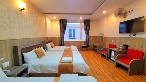 Habitación de hotel con cama, sofá y TV en Dalat Holiday Hotel, en Da Lat