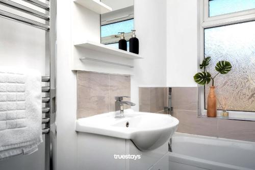 uma casa de banho branca com um lavatório e uma janela em Haydon House by Truestays - NEW 4 Bedroom House in Stoke-on-Trent em Etruria
