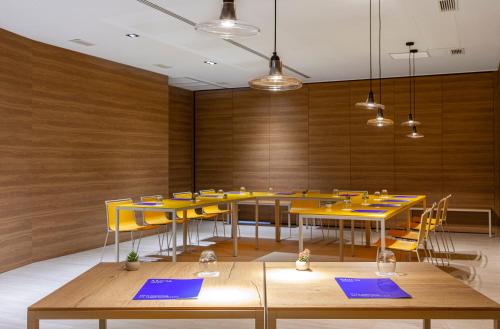 a conference room with yellow tables and yellow chairs at Hotel Macià Sevilla Kubb in Seville