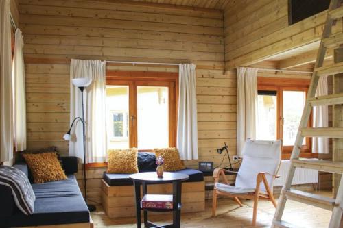 a living room with wooden walls and a couch and chairs at Camping 't Ol Gat in Zoutkamp