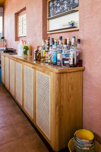 a counter with alcohol bottles on top of it at Villa Yianna in Néa Meságkala