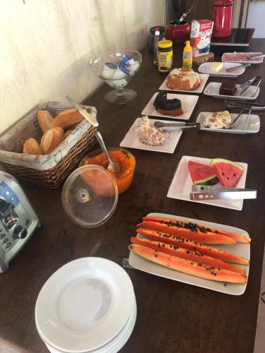 a wooden table with plates of food on it at Pousadinha Lá em Casa in Petrópolis