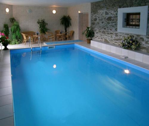 a large blue swimming pool with a table and chairs at Hotel Klor in Doudleby