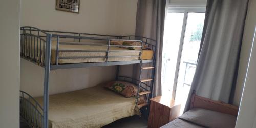 a bedroom with two bunk beds and a window at Uniquely located on the beach in Ayia Marina