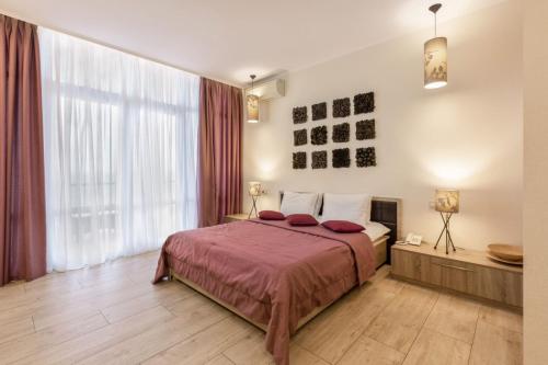 a bedroom with a large bed and a large window at Design Hotel Skopeli in Odesa