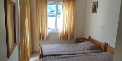 a bedroom with a bed and a window at Uniquely located on the beach in Ayia Marina