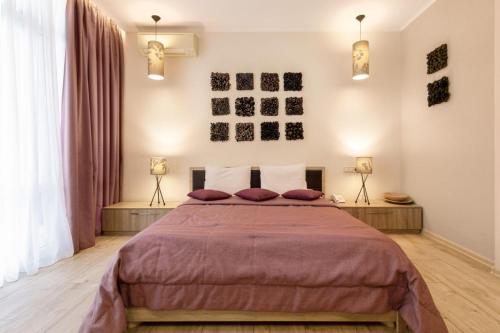 a bedroom with a large bed and two lamps at Design Hotel Skopeli in Odesa