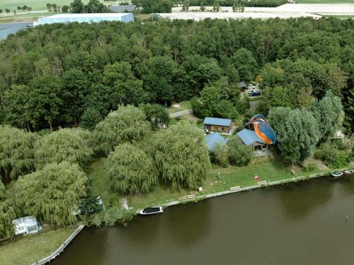 an aerial view of a house on an island in the water at Camping 't Ol Gat in Zoutkamp
