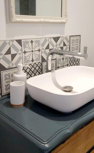 - un lavabo blanc sur un comptoir dans la salle de bains dans l'établissement Sharecroppers Cottage with Swimming Pool, à Pagéas