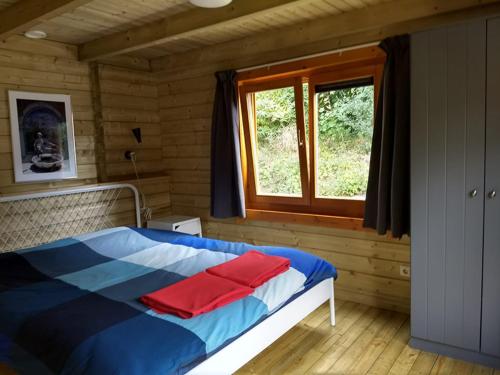 a bedroom with a bed with red pillows on it at Camping 't Ol Gat in Zoutkamp