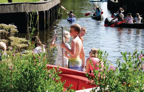 a group of children standing on a boat in the water at Camping 't Ol Gat in Zoutkamp