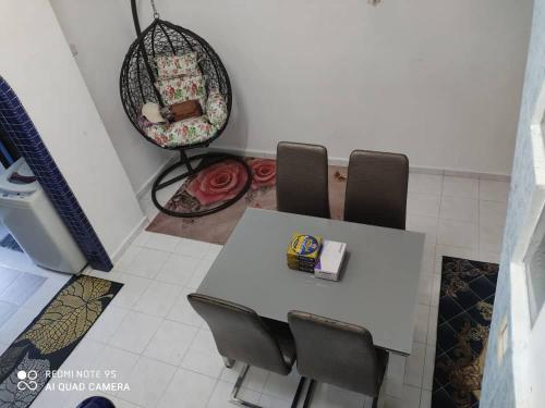 a dining room with a table and chairs and a mirror at R&R HOMESTAY in Simpang Renggam