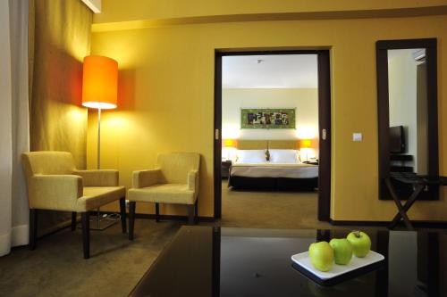 a room with a bedroom with a bed and a mirror at Vila Gale Coimbra in Coimbra