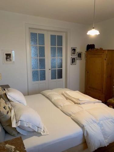 białe łóżko w pokoju z oknem w obiekcie Huis Agnes w Ostendzie