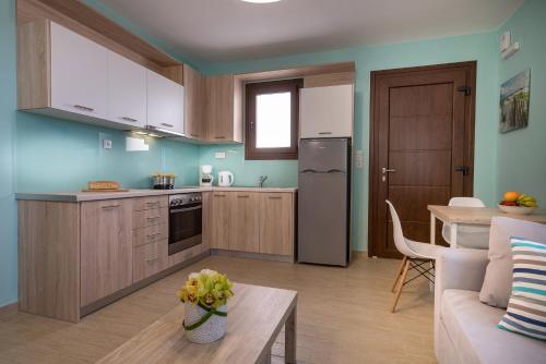 a kitchen and living room with a couch and a table at Stella in the Village Suites in Plakias