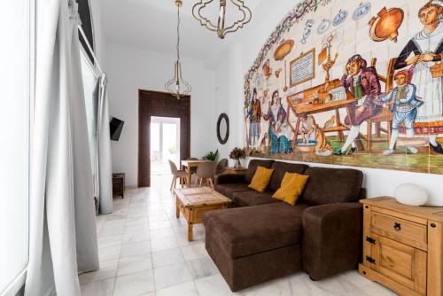 uma sala de estar com um sofá e uma pintura na parede em Casa Palacio Sanlúcar de Barrameda em Sanlúcar de Barrameda