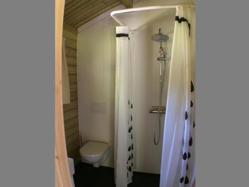 a bathroom with a toilet and a shower curtain at Camping 't Ol Gat in Zoutkamp