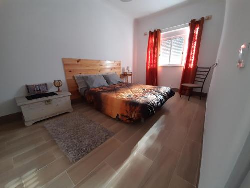 a bedroom with a bed and a table and a window at Casa Terra Cota - Seixal in Amora
