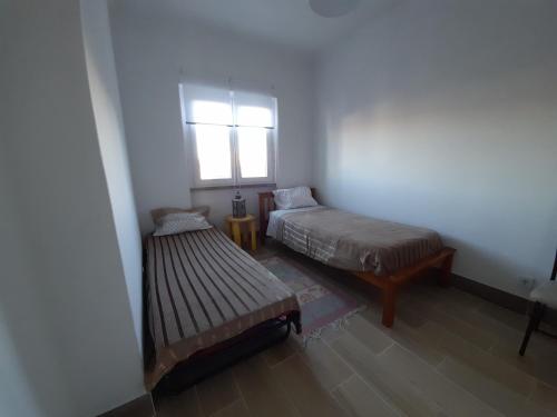 Habitación pequeña con cama y ventana en Casa Terra Cota - Seixal en Amora